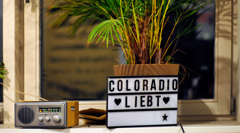 Ein Radio und unser Schild "Coloradio liebt"