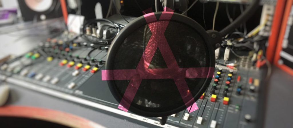 Mischpult mit Mikrofon und Anarchismussymbol