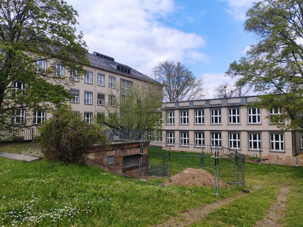 Das Bild zeigt zwei Gebäude der TU Dresden, vor ihnen ist eine Wiese.
