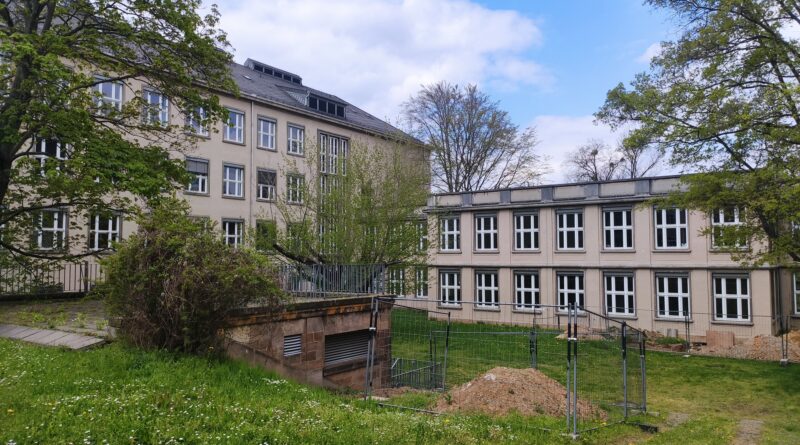 Das Bild zeigt zwei Gebäude der TU Dresden, vor ihnen ist eine Wiese.