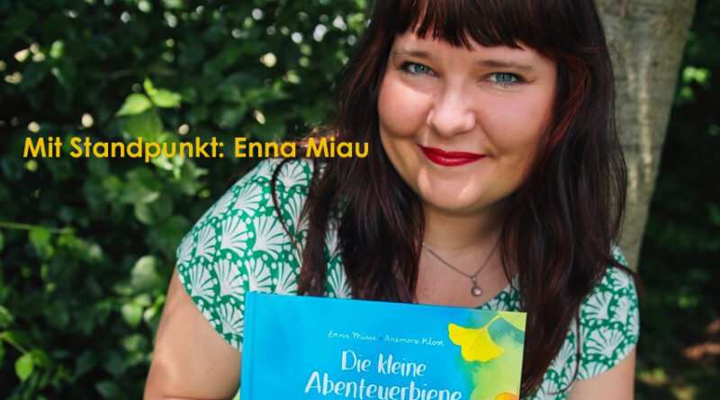 Eine Frau hält ein das Buch: Die kleine Abenteuerbiene. Auf dem Bild steht: Mit Standpunkt: Enna Miau.