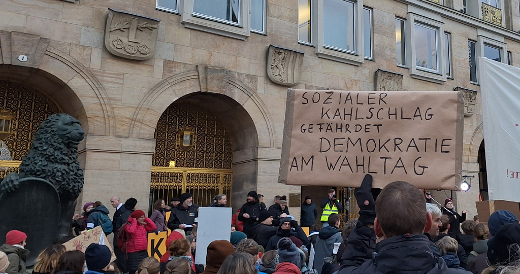 Demonstrierende stehen vor dem Rathaus in Dresden