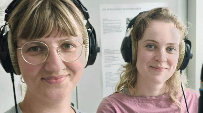 Zwei Frauen mit Kopfhörern auf im Aufnahmestudio.